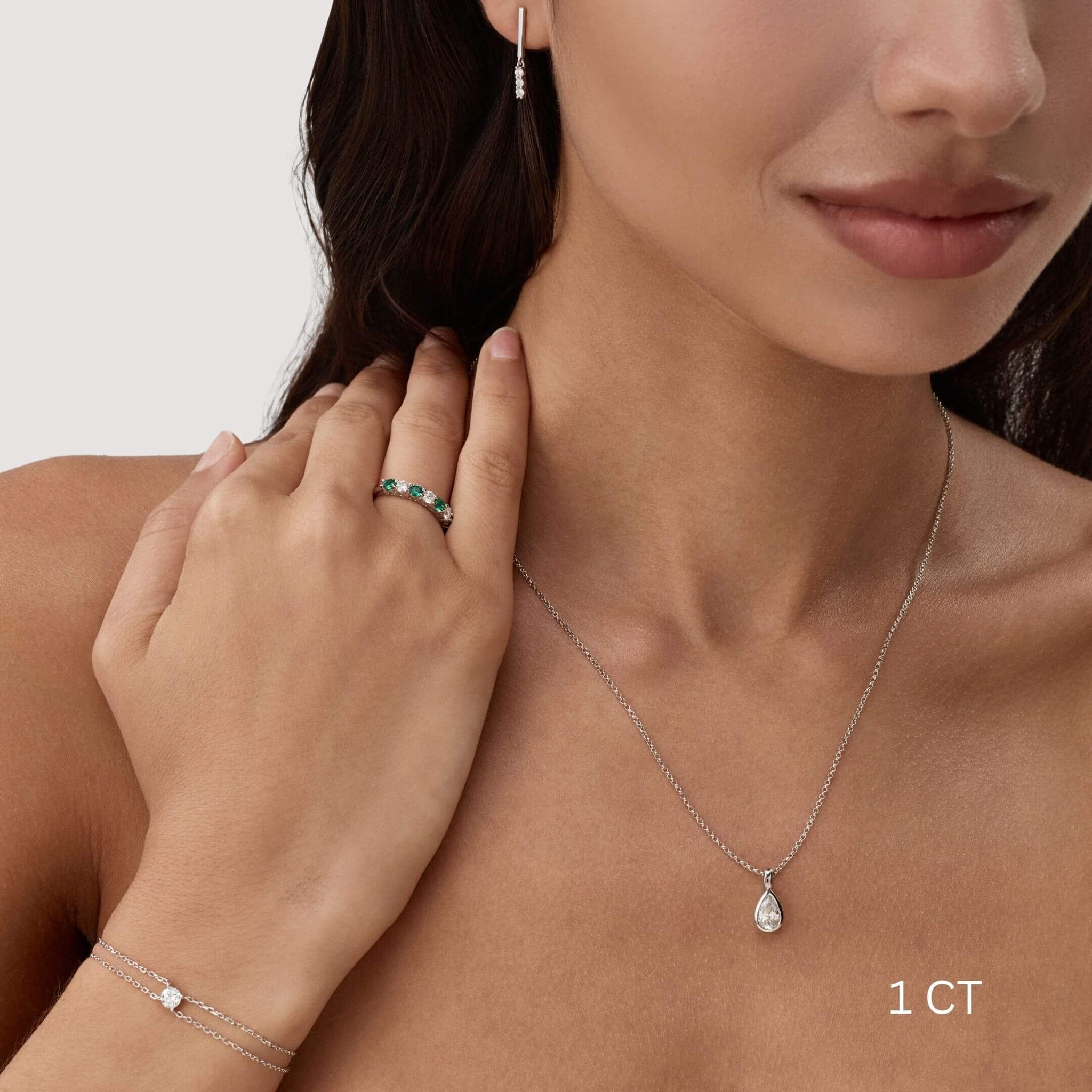 Pear-cut moissanite bezel pendant necklace worn at the neckline.