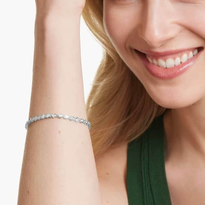 Pear-cut moissanite bezel tennis bracelet worn on the wrist.