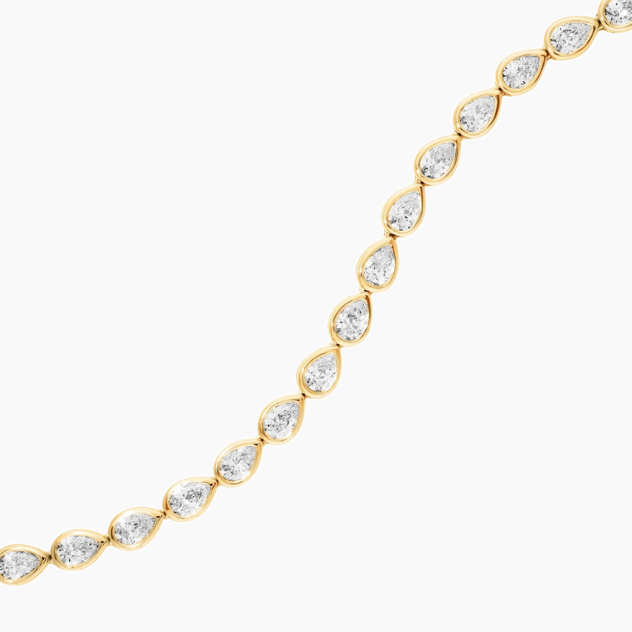 Pear-cut moissanite bezel tennis bracelet in yellow gold vermeil, close-up detail.