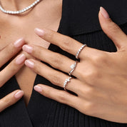 Pear-cut moissanite chevron ring worn on a finger.