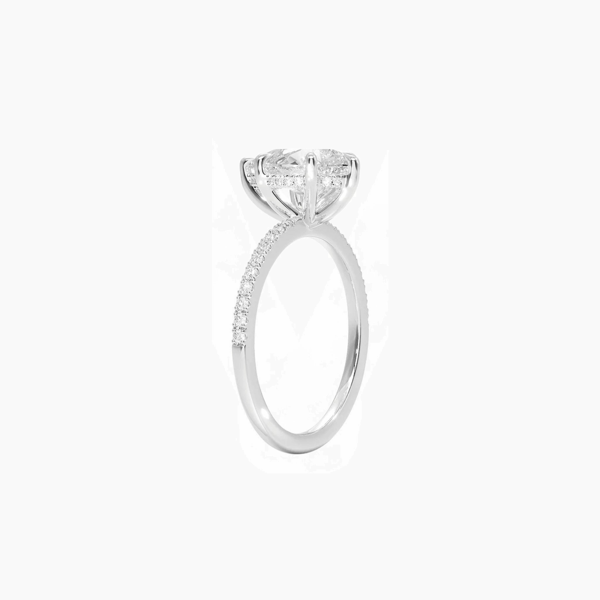 Pear-cut moissanite hidden halo ring with pavé band in white gold vermeil, side view.