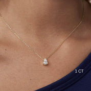 Pear-cut moissanite pendant necklace worn at the neckline.