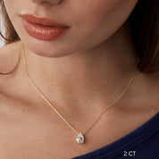 Pear-cut moissanite pendant necklace worn at the neckline.