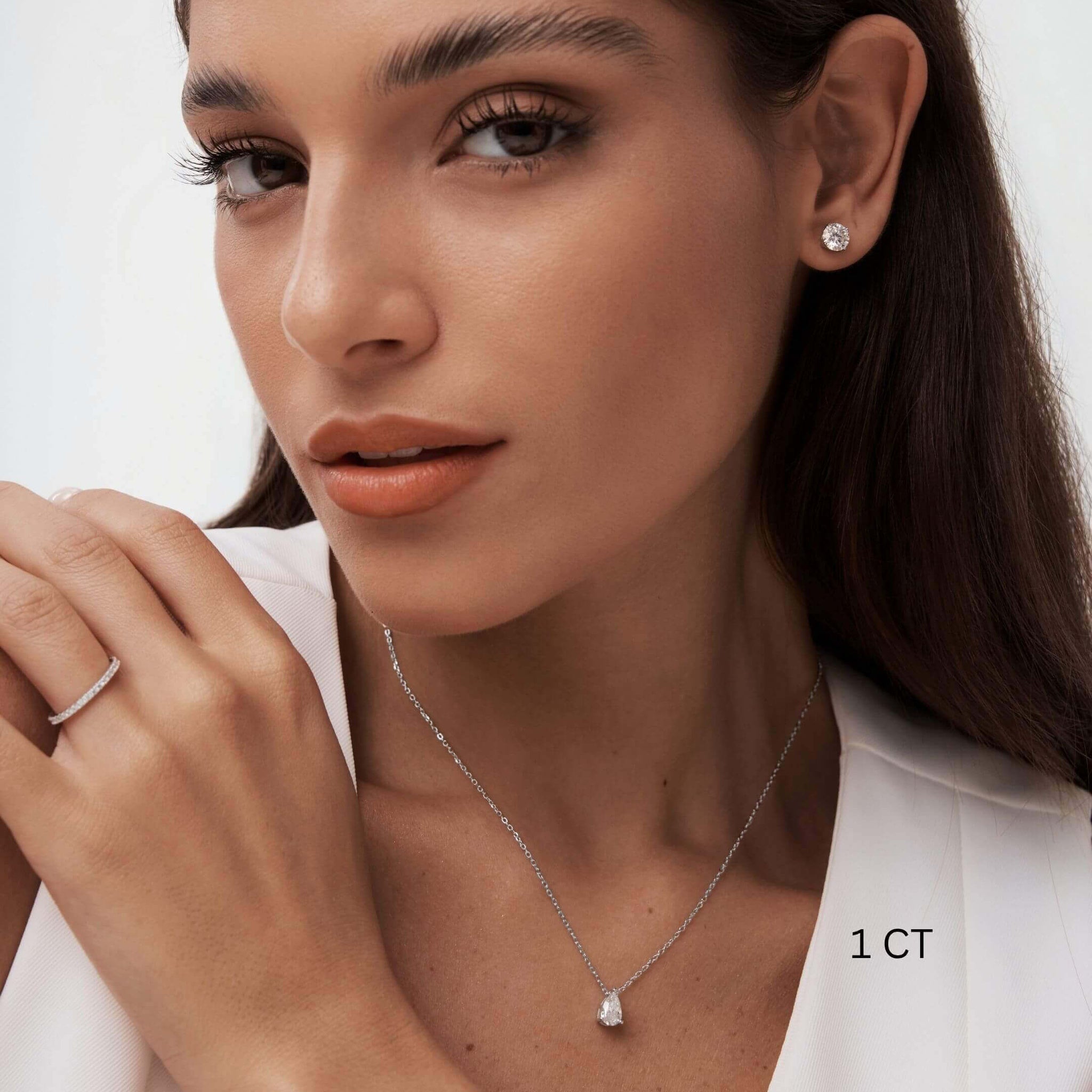 Pear-cut moissanite pendant necklace worn at the neckline.