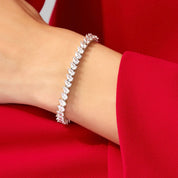 Pear-cut moissanite tennis bracelet worn on the wrist.