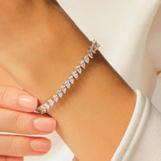 Pear-cut moissanite tennis bracelet worn on the wrist.