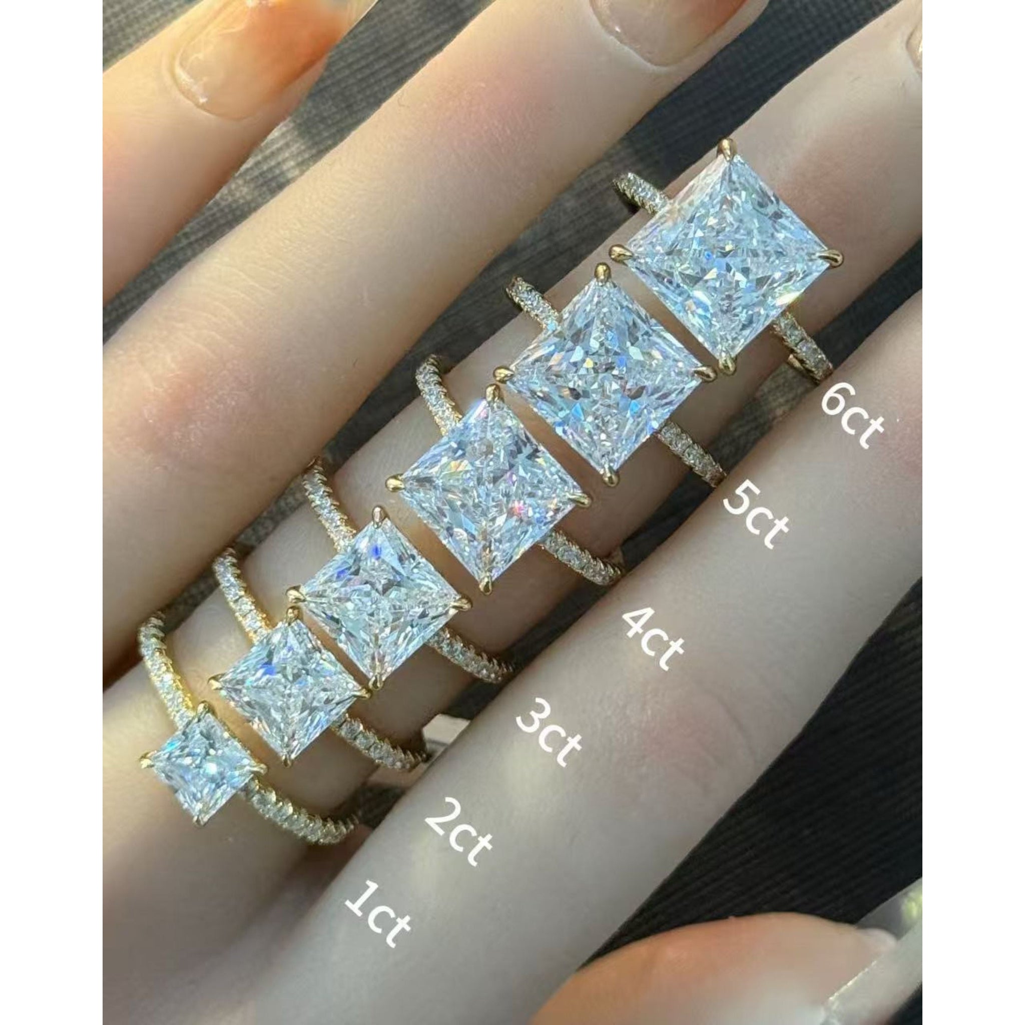Princess-cut moissanite hidden halo ring with pavé band rings arranged across fingers for a carat-size comparison.