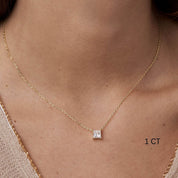 Princess-cut moissanite pendant necklace worn at the neckline.