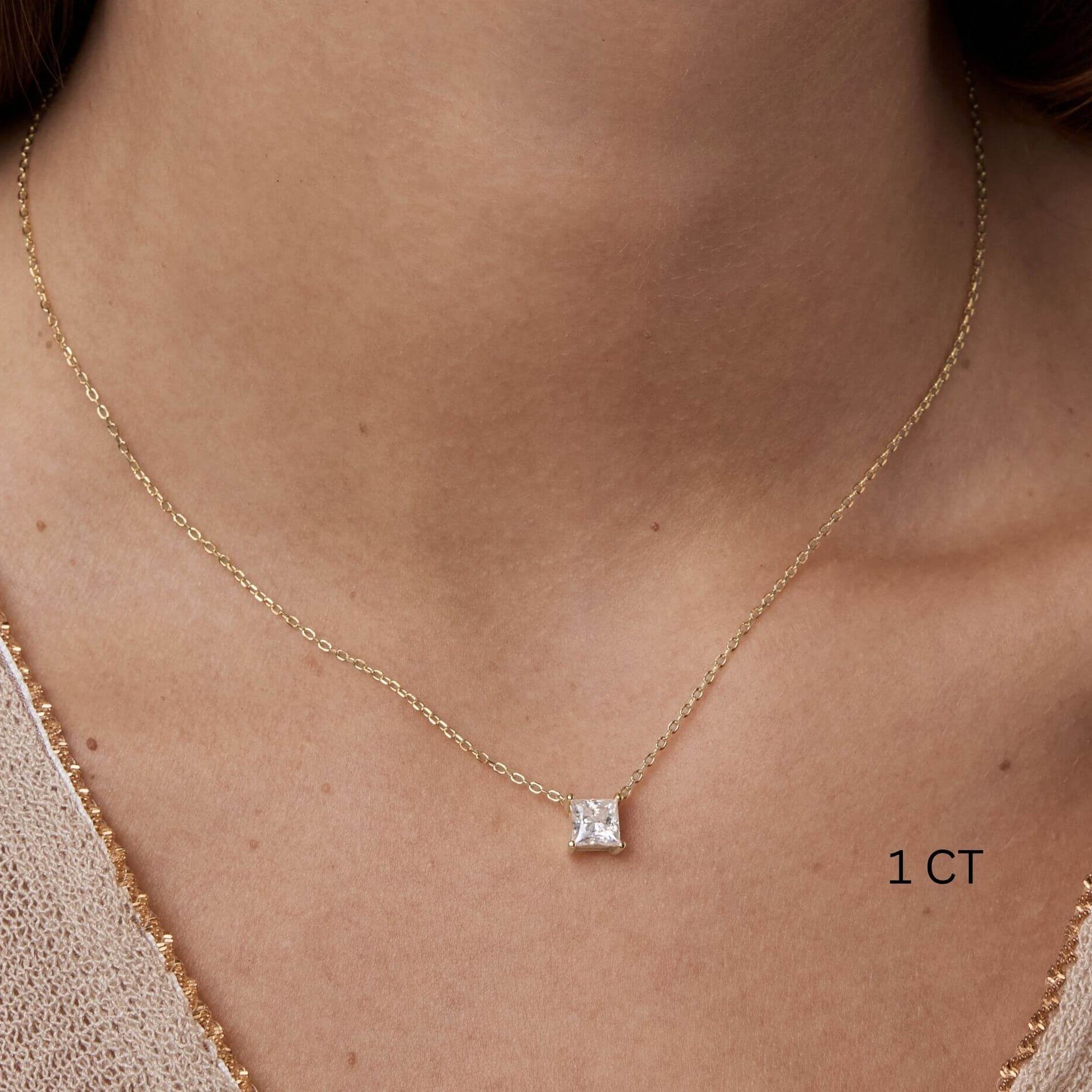 Princess-cut moissanite pendant necklace worn at the neckline.