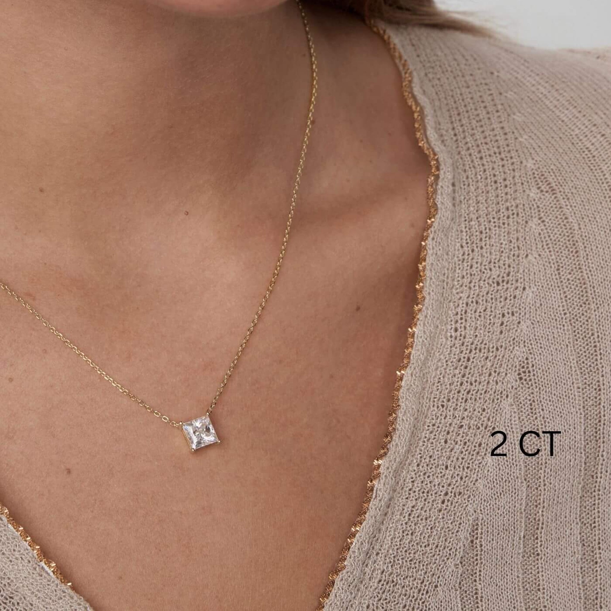 Princess-cut moissanite pendant necklace worn at the neckline.
