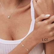 Princess-cut moissanite pendant necklace worn at the neckline.