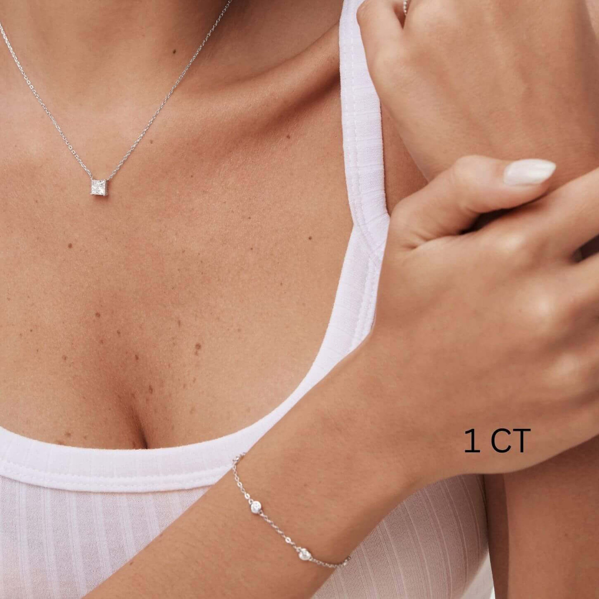 Princess-cut moissanite pendant necklace worn at the neckline.