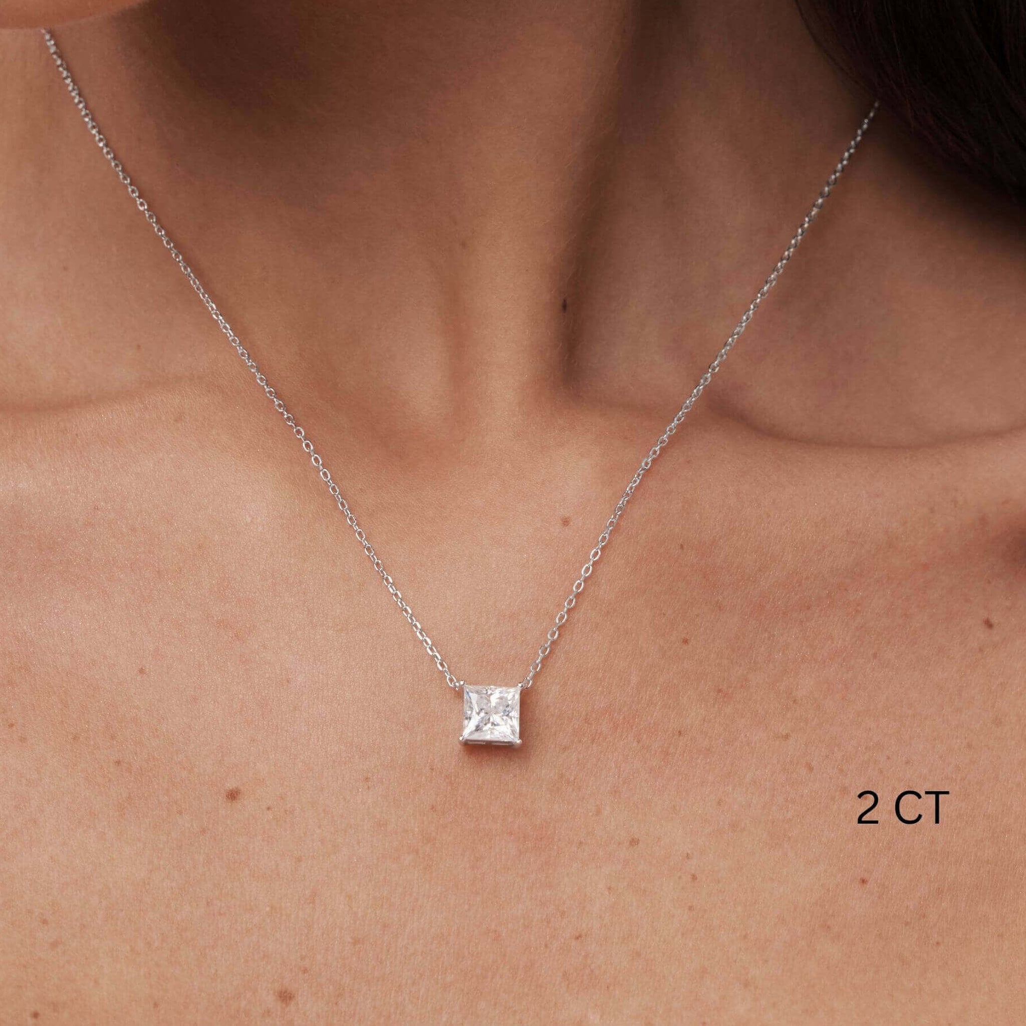 Princess-cut moissanite pendant necklace worn at the neckline.