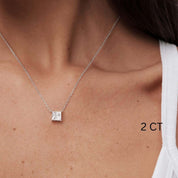 Princess-cut moissanite pendant necklace worn at the neckline.