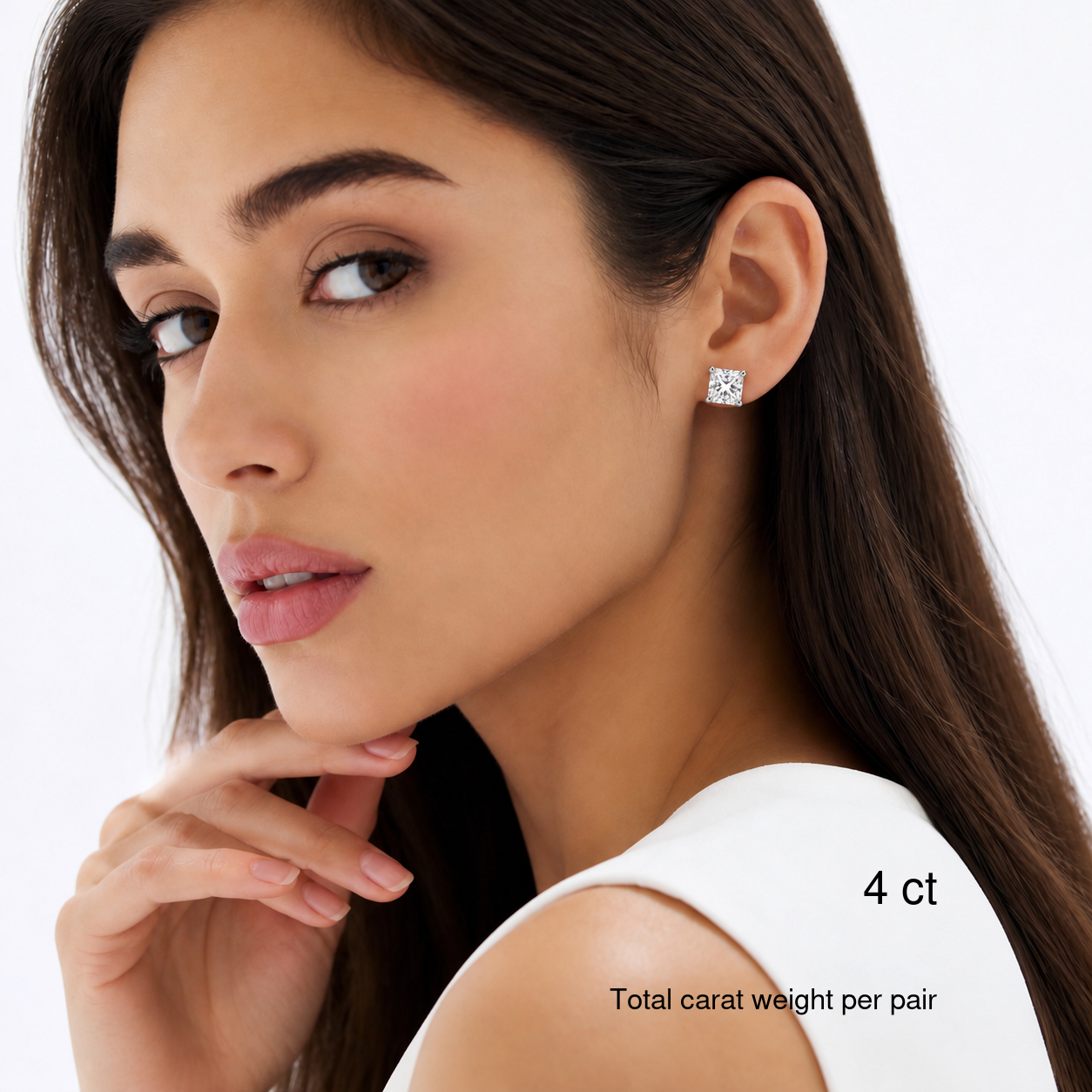 Princess-cut white gold stud earrings worn on a model, 4 ct total carat weight per pair.