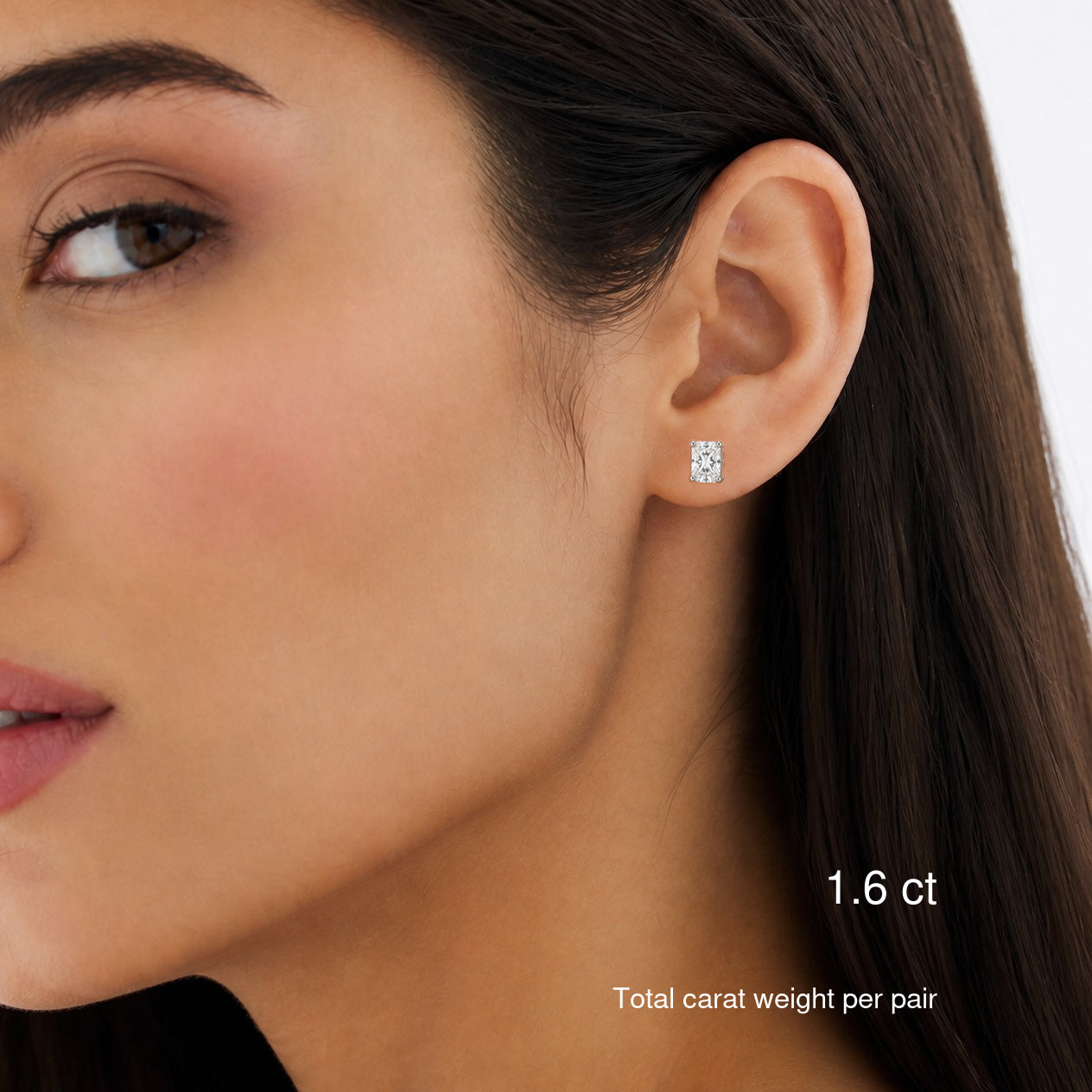 Radiant-cut lab-grown diamond stud earrings in 14k white gold worn on a model, 1.6 ct total carat weight per pair.