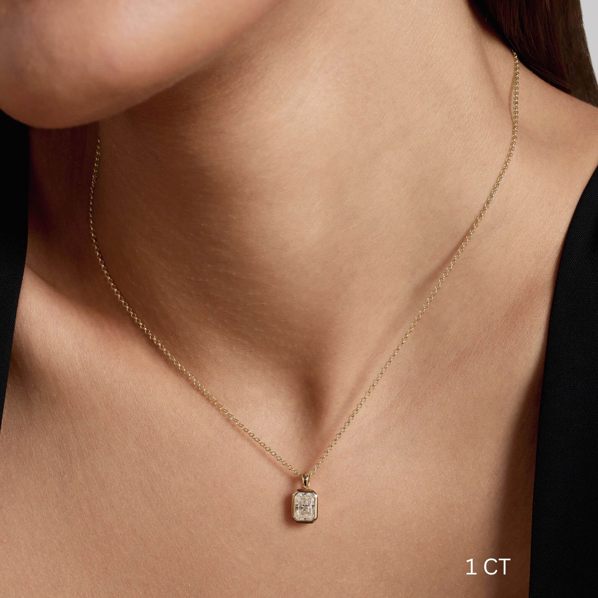 Radiant-cut moissanite bezel pendant necklace worn at the neckline.