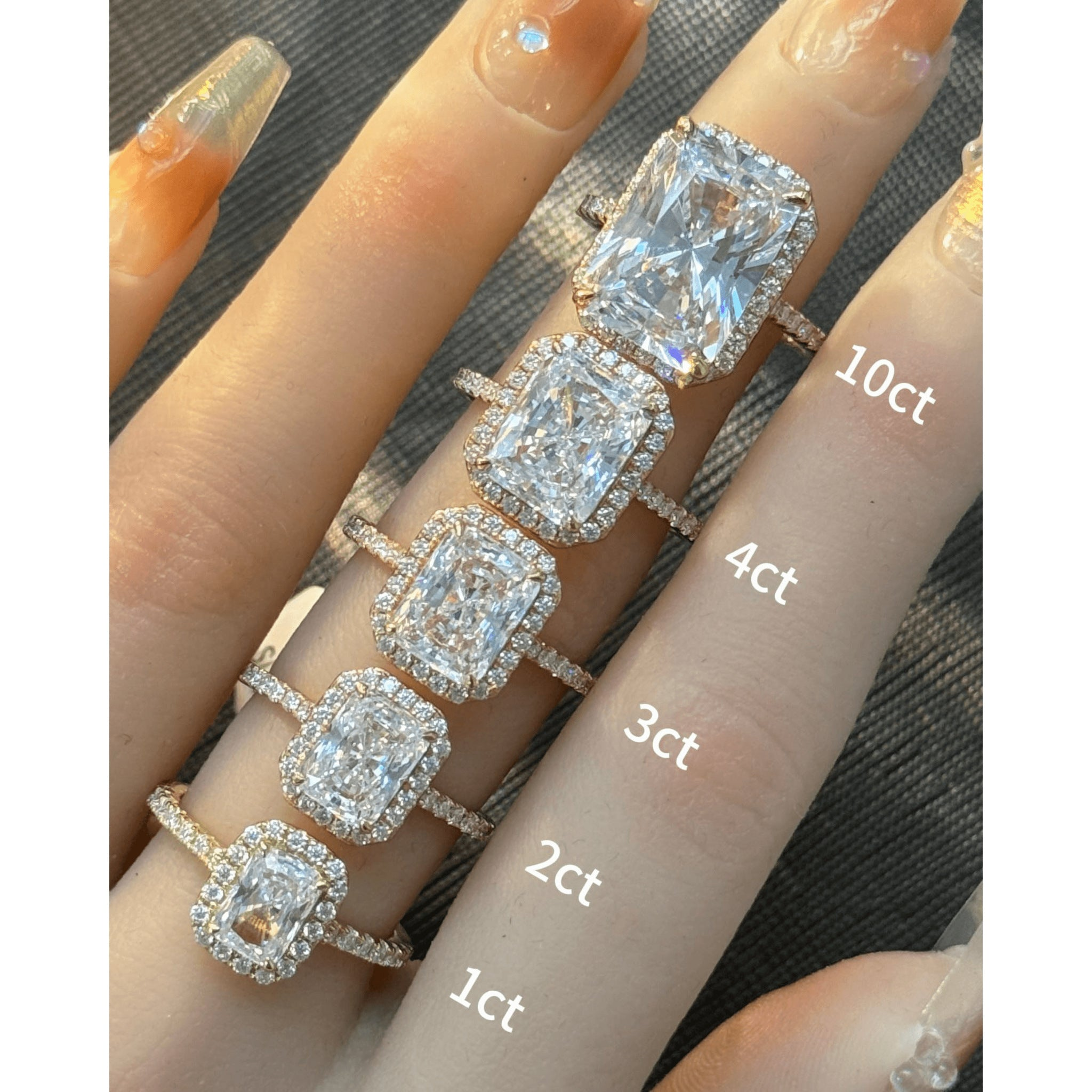 Radiant-cut moissanite halo ring with pavé band rings arranged across fingers for a carat-size comparison.