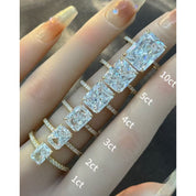 Radiant-cut moissanite hidden halo ring with pavé band rings arranged across fingers for a carat-size comparison.