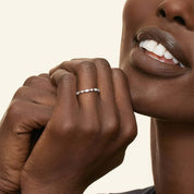 Round-cut and marquise-cut moissanite half eternity ring worn on a finger.