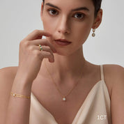 Round-cut moissanite bezel pendant necklace worn at the neckline.