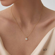 Round-cut moissanite bezel pendant necklace worn at the neckline.