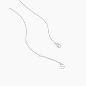 Round-cut moissanite bezel pendant necklace in white gold vermeil, clasp and chain-end detail.