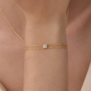 Round-cut moissanite double-chain bracelet worn on the wrist.