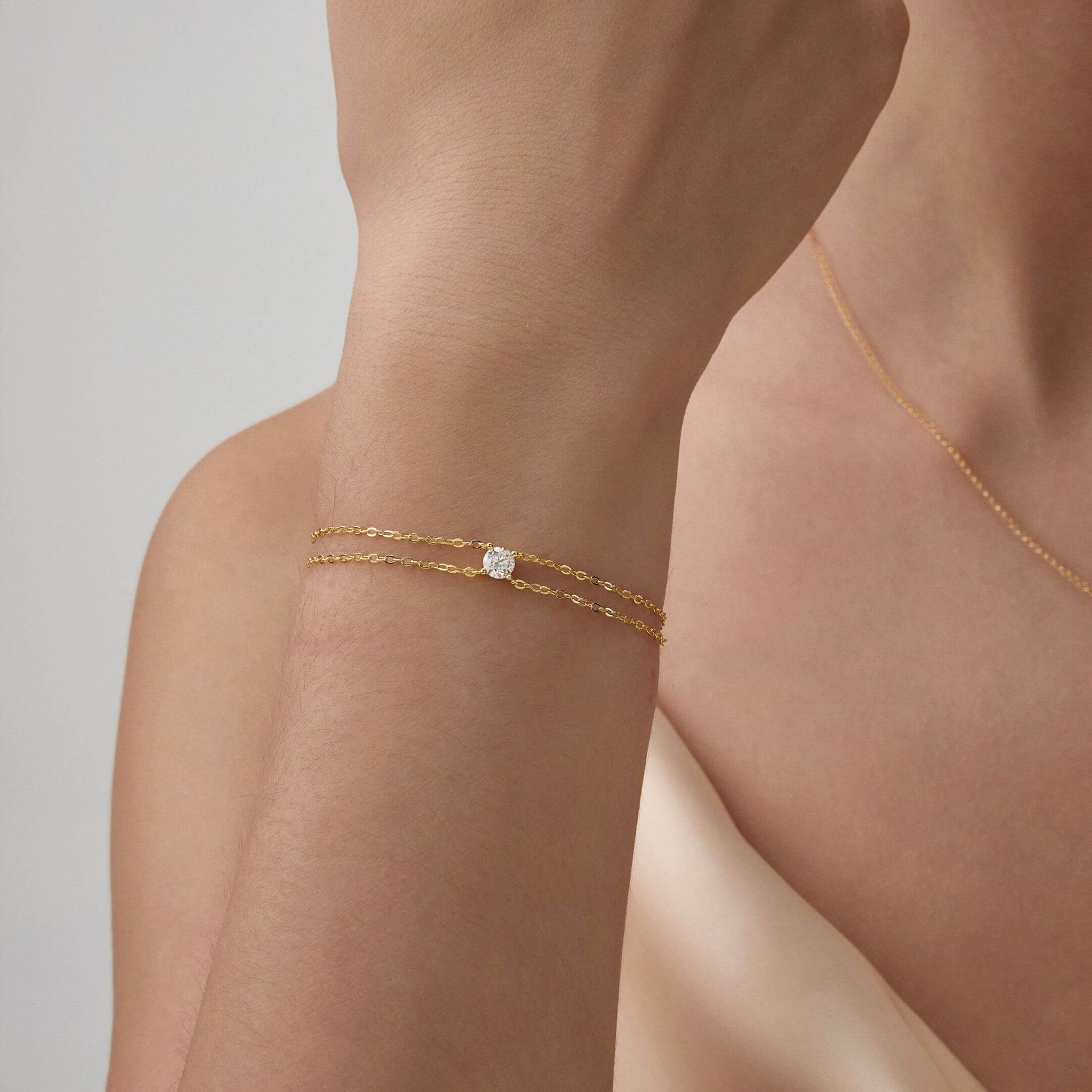 Round-cut moissanite double-chain bracelet worn on the wrist.