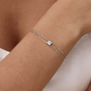 Round-cut moissanite double-chain bracelet worn on the wrist.