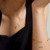 Round-cut moissanite pendant necklace worn at the neckline.