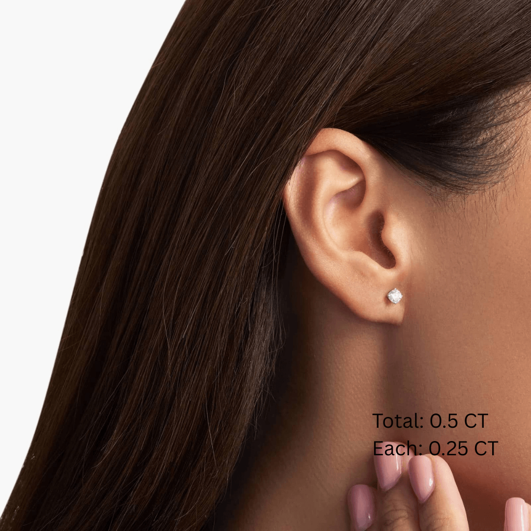 Round-cut moissanite stud earrings worn on the ear, 0.5 ct per pair with 0.25 ct per stone.