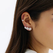 Round-cut moissanite stud earrings different stud sizes shown together on the ear.
