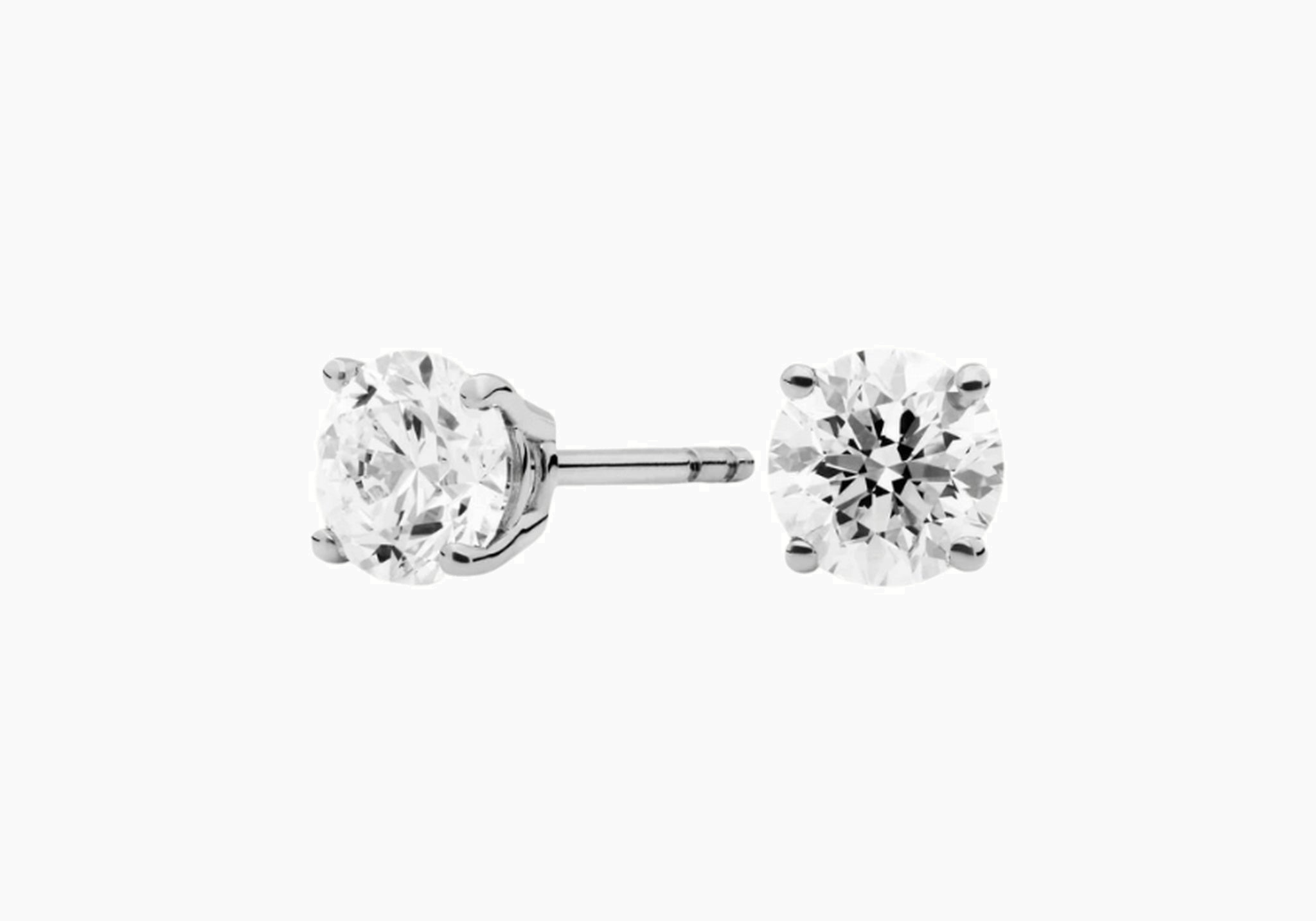 Round-cut moissanite stud earrings in white gold vermeil, front and side views.