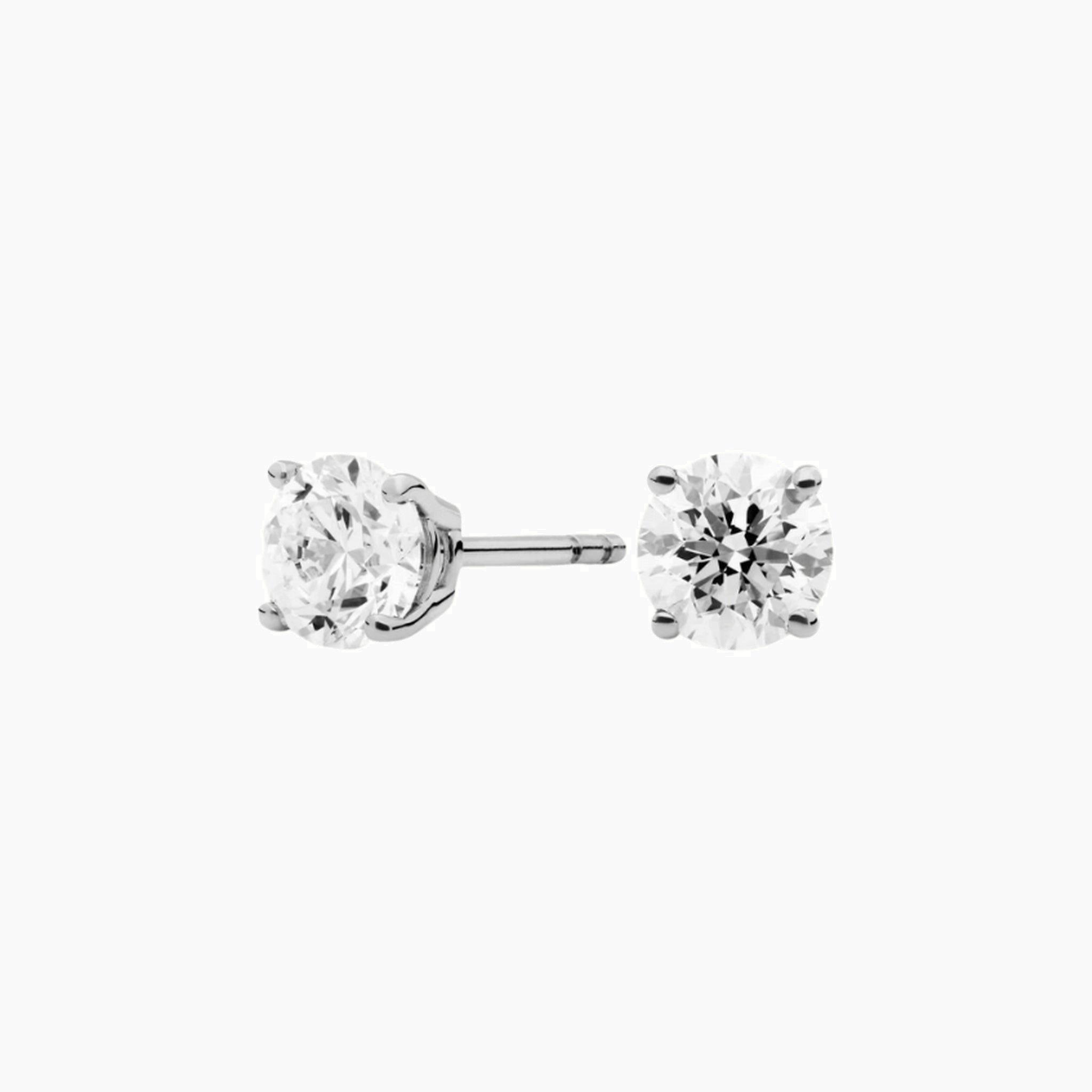 Round-cut moissanite stud earrings in white gold vermeil, front and side views.