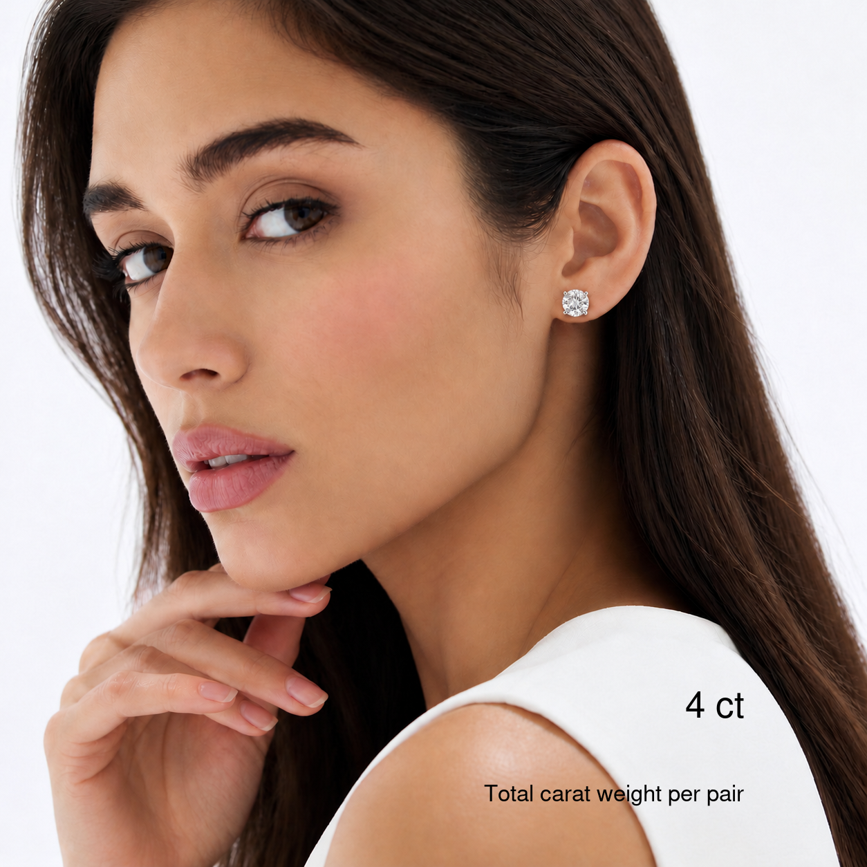 Round-cut moissanite stud earrings in white gold worn on a model, 4 ct total carat weight per pair. Natural bright portrait.
