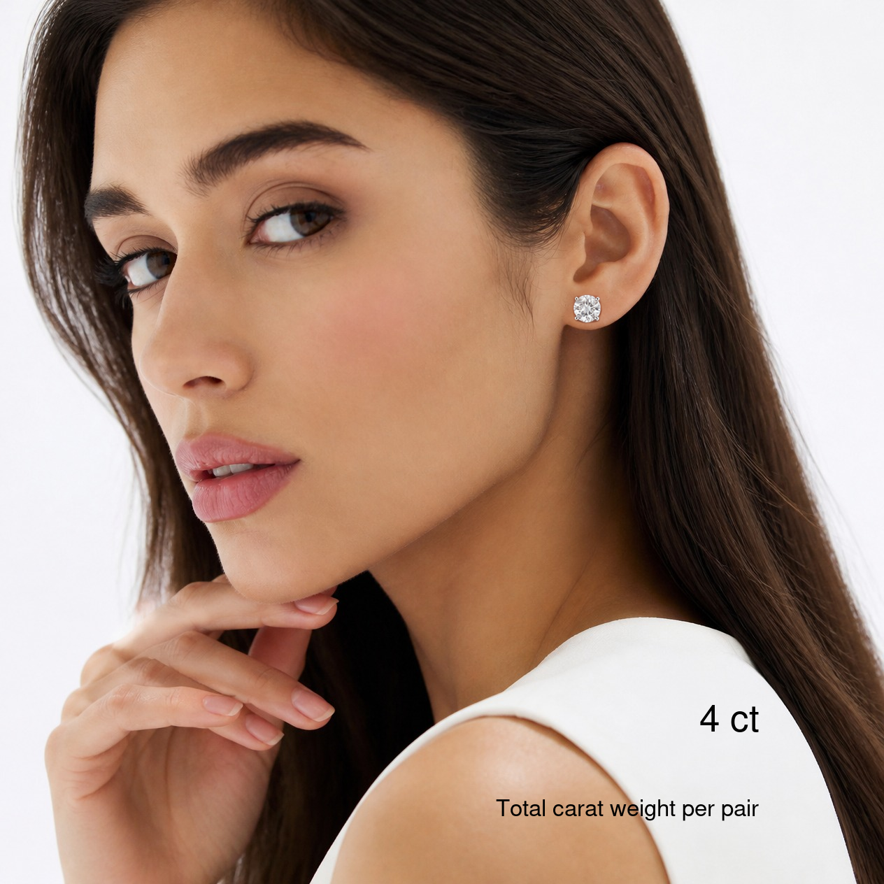 Round-cut moissanite stud earrings in white gold worn on a model, 4 ct total carat weight per pair. Natural bright portrait.