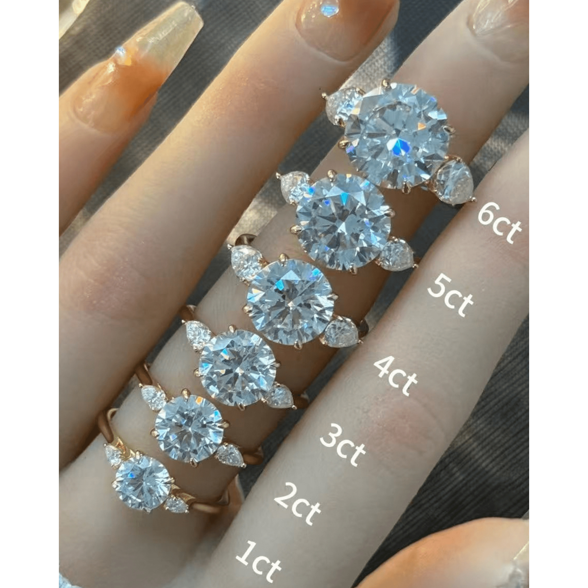 Round-cut moissanite three-stone ring rings arranged across fingers for a carat-size comparison.