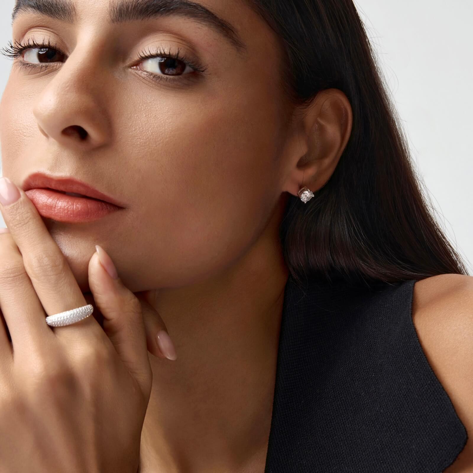 Slim pavé moissanite dome ring worn on a finger.
