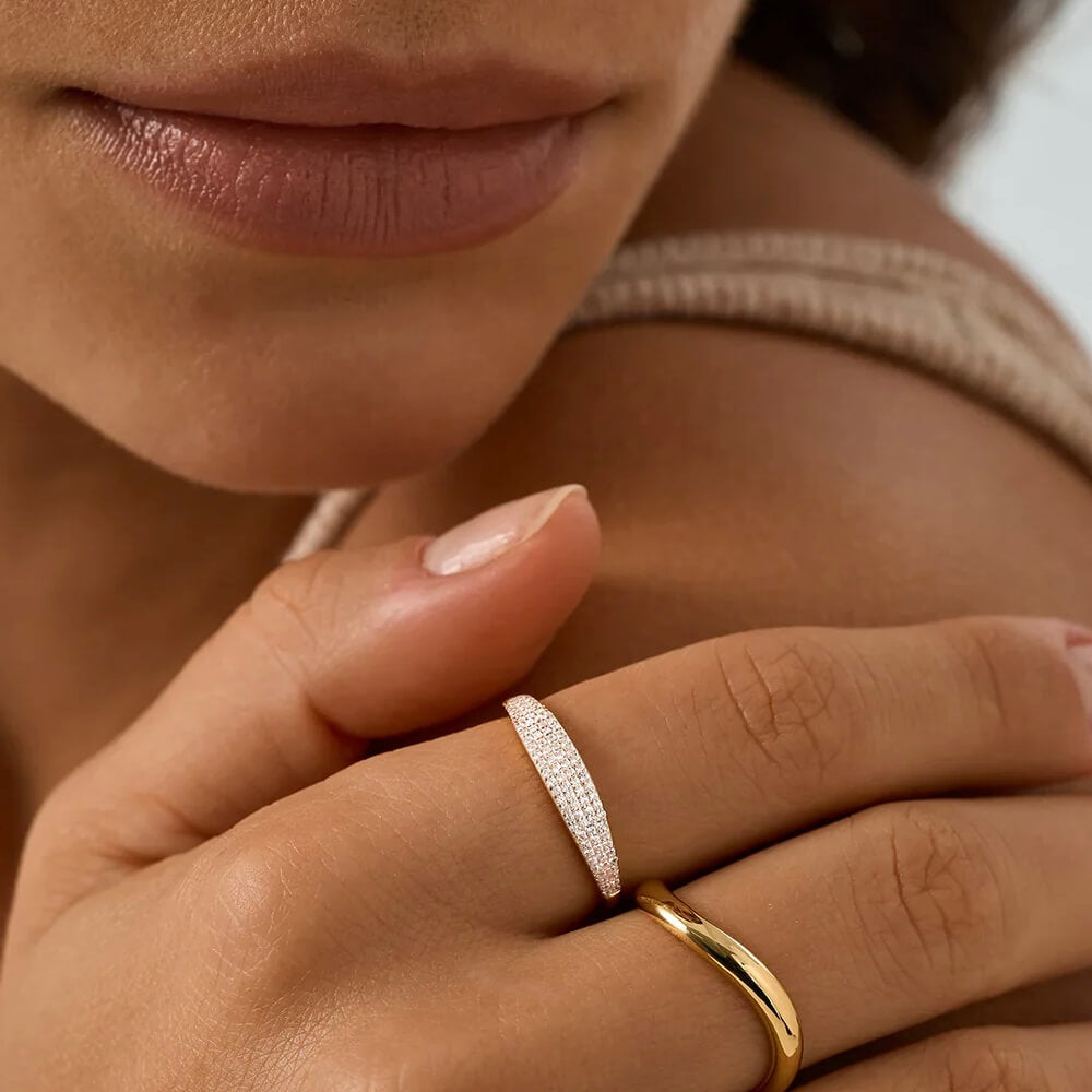 Slim pavé moissanite signet ring worn on a finger.