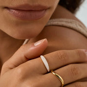 Slim pavé moissanite signet ring worn on a finger.