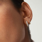 Small bold pavé moissanite hoop earrings worn on the ear.