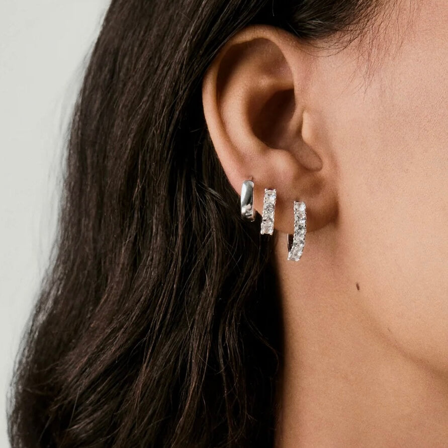 Small moissanite hoop earrings worn on the ear.