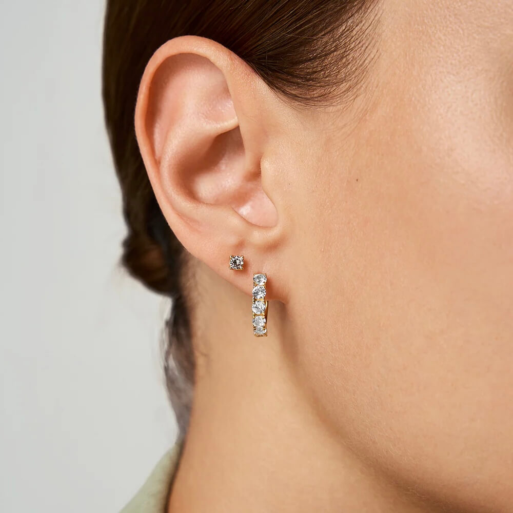 Small moissanite hoop earrings worn on the ear.
