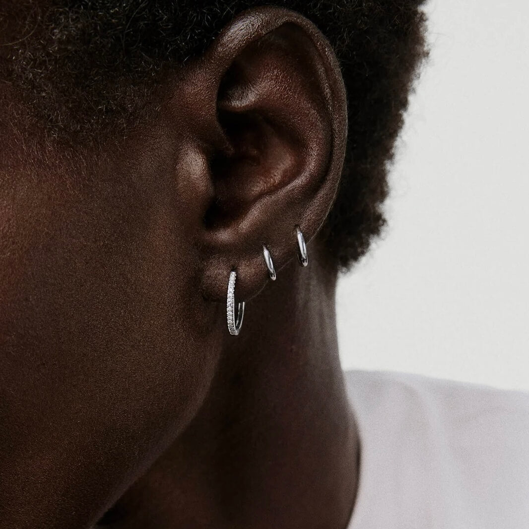 Small pavé moissanite hoop earrings worn on the ear.