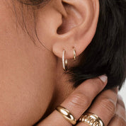 Small pavé moissanite hoop earrings worn on the ear.
